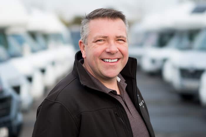 Headshot of company director in from of motorhomes